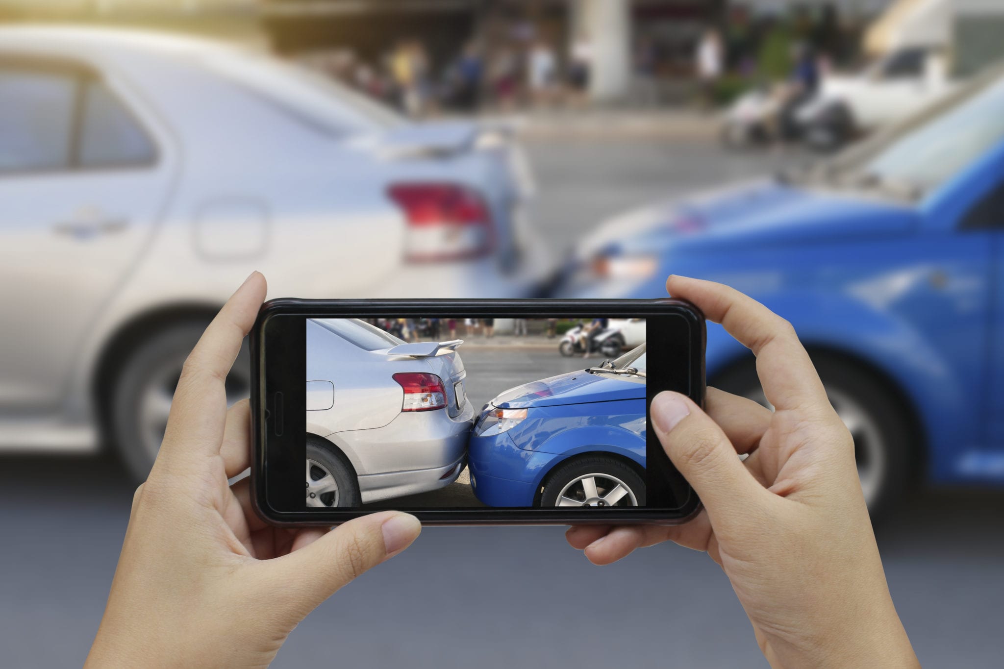 Close up hand holding smartphone and take photo at The scene of a car crash and accident, car accident for car insurance claim.