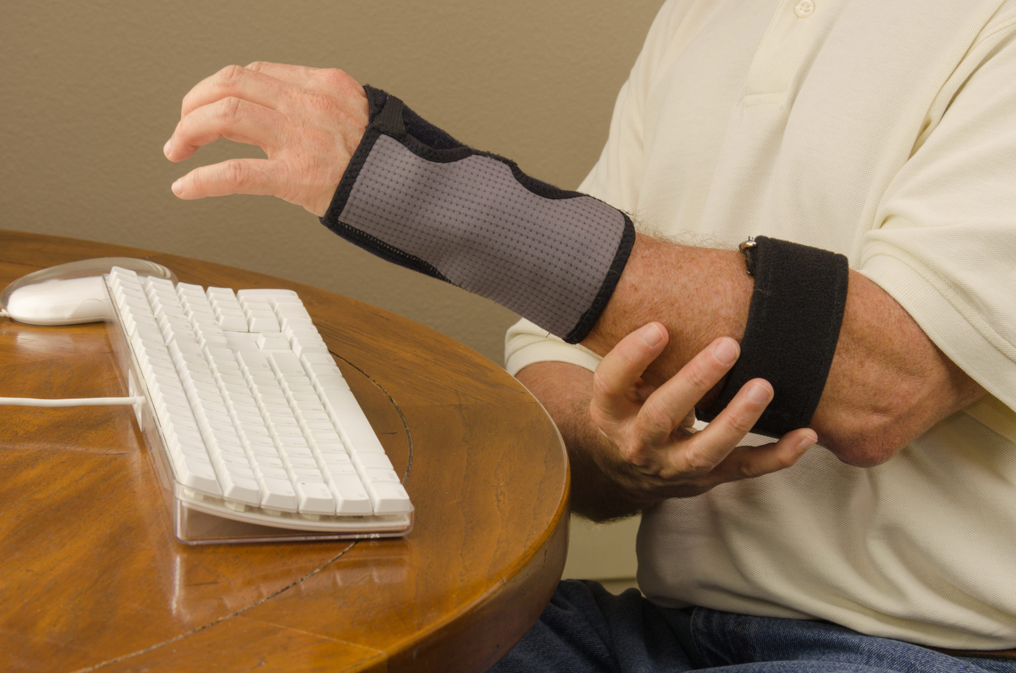 A man is experiencing computer use pain with tendinitis, carpal tunnel syndrome and repetitive stress injury very common to people who work on computers all day. These issues also affect athletes, mechanics and many other professions that require the same arm movement over and over.
